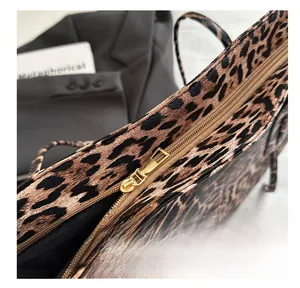 Close-up of golden metal zipper closure on leopard print tote bag with smooth texture