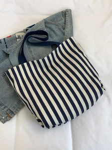 Overhead view of large capacity blue and white striped canvas tote bag with navy handles