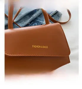 Detail view of brown PU leather handbag featuring elegant flip cover and fashion bags lettering