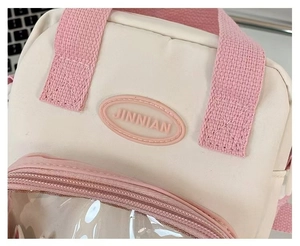 Detail of clear PVC window on mini crossbody bag with JINNIAN brand rubber patch