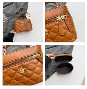 Detail view of brown quilted handbag with golden camellia hardware and chain strap