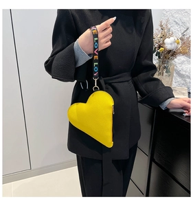 Detail of heart-shaped yellow leather handbag with lychee texture and LOVE wristlet