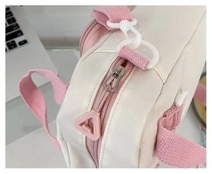 Detail of pink metal zipper and high-density nylon fabric on the mini shoulder bag