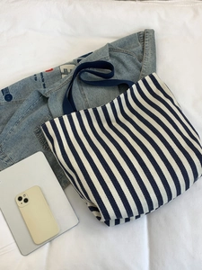 Blue and white striped canvas tote bag shown with a tablet and denim jacket