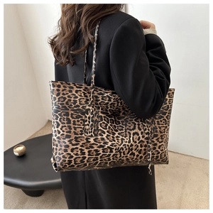 Detailed back view of a stylish leopard print tote bag worn on a woman's shoulder