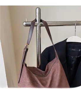 Dettaglio della borsa tote in pelle scamosciata marrone con tracolla regolabile e zip