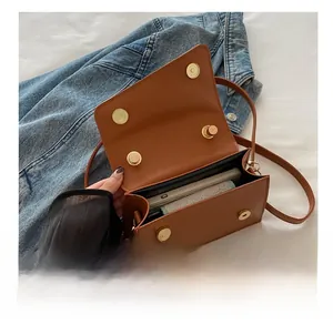 Macro view of compact brown crossbody bag interior showing phone storage capacity
