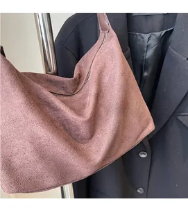 Dettaglio della borsa a spalla in morbida pelle scamosciata marrone-viola con zip