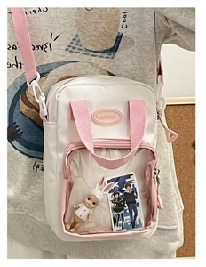 Detail of pink and white canvas ita bag featuring a clear front window for mini plushies