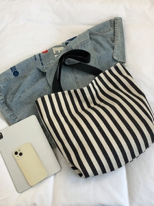 Detail of black and white striped canvas tote bag with large capacity and textile straps