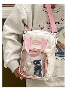 Detail of clear PVC window on cream ita bag showing anime cards and plush rabbit