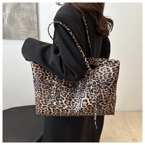 Detailed view of large leopard print tote bag styled with a professional black blazer