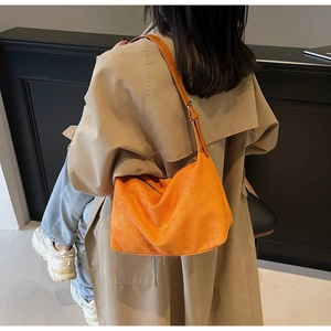 Dettaglio della borsa hobo in camoscio arancione con tracolla regolabile e fibbie metalliche