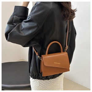 Detail view of the small brown PU leather crossbody bag with a semi-circular handle
