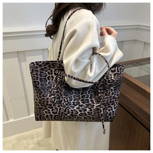 Detailed view of the large leopard print tote bag being worn on the shoulder by a model