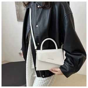 Detail view of a white leather crossbody bag showing smooth PU finish and gold logo lettering