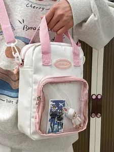 Mini white crossbody ita bag with clear window and pink straps for pins and dolls
