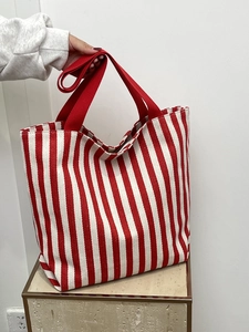 Close-up of red and white striped canvas tote bag showing thick fabric texture and straps