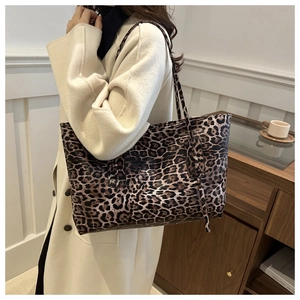 Detail view of the large capacity leopard print tote bag worn on shoulder by a model