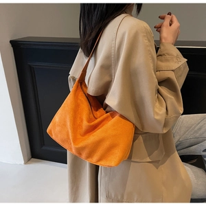 Dettaglio della borsa tote in pelle scamosciata arancione vivace con zip e tracolla larga morbida