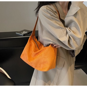 Dettaglio della borsa tote in pelle scamosciata arancione con cerniera in metallo