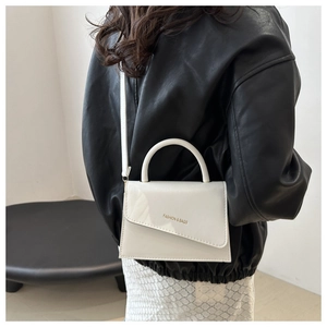 Chic cream white crossbody bag with asymmetric flap and fashion logo shown on model