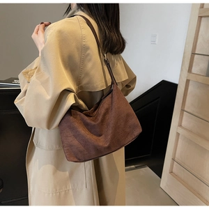 Dettaglio di una borsa hobo in pelle scamosciata marrone scuro in stile vintage minimalista