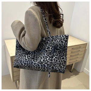 Detail of large leopard print tote bag styled with a wool coat for a chic autumn look