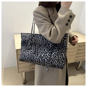 Detailed view of leopard print tote bag with long straps worn on shoulder for commuting