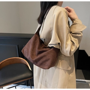 Vista laterale di una borsa tote grande in pelle scamosciata marrone con una modella
