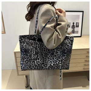 Chic leopard print tote bag styled as a shoulder bag on a model in a minimalist room