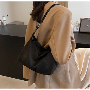 Dettaglio della grande borsa hobo in pelle scamosciata nera con tracolla regolabile