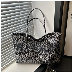 Detail of stylish leopard print tote bag with dual straps on a sunlit window sill