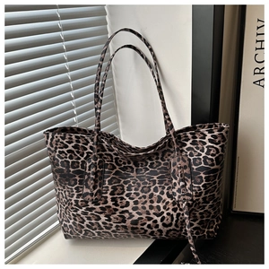 Macro view of leopard print tote bag with textured faux leather and slim shoulder straps