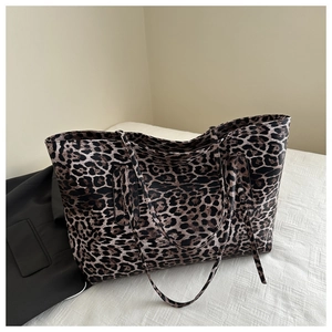 Close-up of leopard print tote bag with double straps against a minimalist backdrop