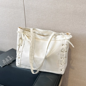 Glossy white tote bag with ribbon bow drawstrings and dual shoulder straps for women