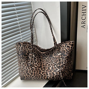 Detail showing magnetic snap closure and leopard print texture on spacious tote bag