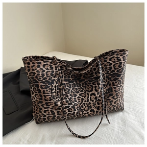 Detailed close-up of large leopard print tote bag with soft fabric texture and dual straps
