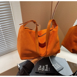 Dettaglio borsa tote in pelle scamosciata arancione con tracolla regolabile e fibbia in metallo