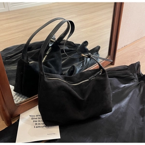 Dettaglio della borsa tote nera in finto camoscio con zip e tracolla regolabile