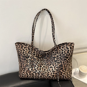 Classic leopard print tote bag with black handles in a stylish lifestyle setting