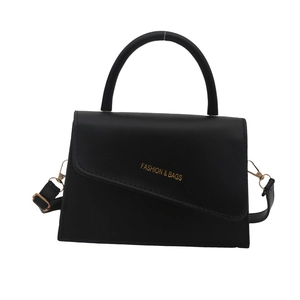 Minimalist black trapezoid handbag with asymmetrical flap and adjustable shoulder strap