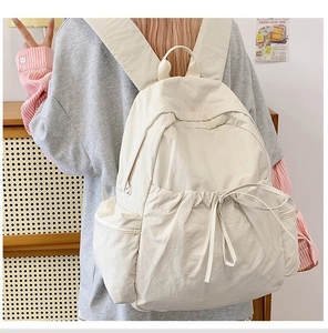 Detailed back view of a minimalist cream waterproof nylon travel backpack for women