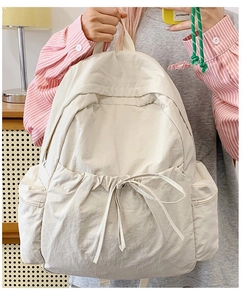Detail of minimalist beige nylon backpack with drawstring pocket and spacious main storage
