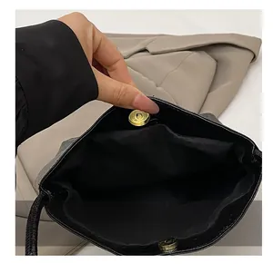 Detail shot of black leather bucket bag showing the golden magnetic snap closure