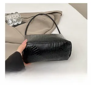 Detail showing the durable bottom and crocodile pattern of the black bucket bag