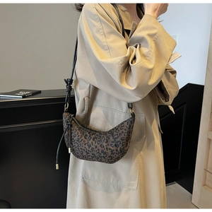 Detail of leopard print canvas croissant bag featuring knotted black leather ties