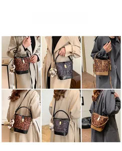 Detail view of leopard print bucket bag with gold clasp and cute bear charm accessory