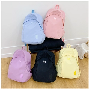 Collection of minimalist nylon backpacks in blue, pink, purple, black, and yellow colors