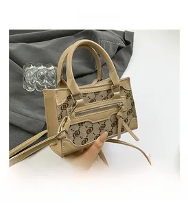 Close-up of beige crossbody bag with textured fabric, leather trim and long tassel detail